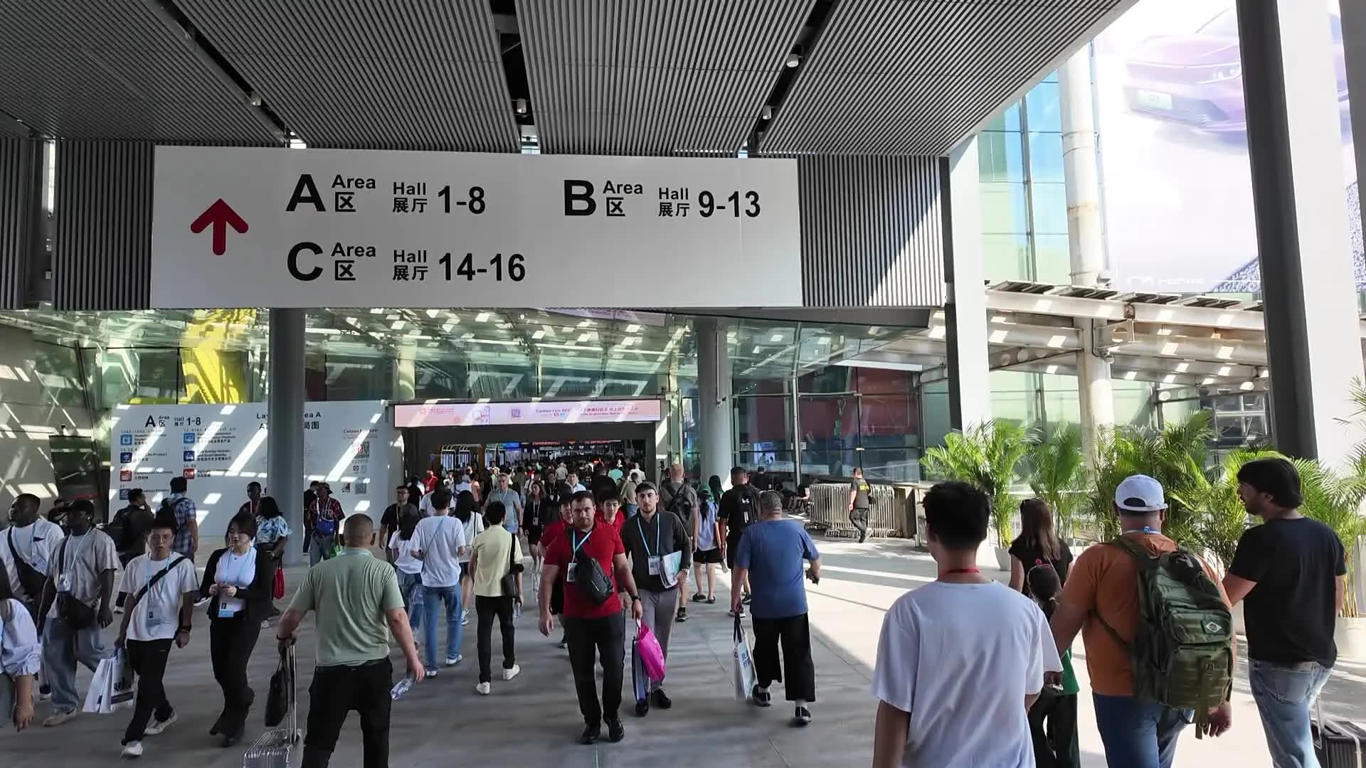 Entrance to the Canton Fair complex: a sign for areas A, B and C and a stream of visitors
