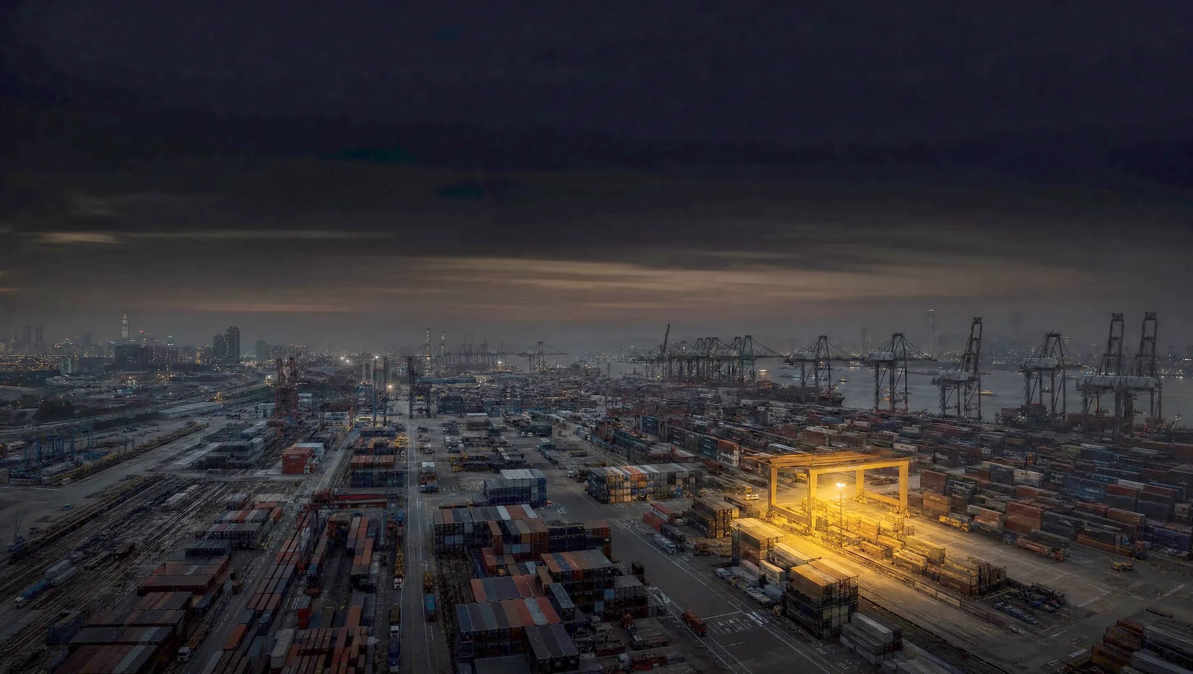 Container port at night, one gantry crane lit in yellow